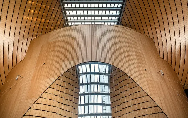 Modern wood-clad concert hall interior with a long glass skylight