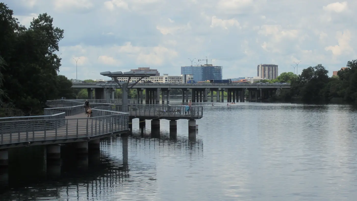 Lady Bird Lake boardwalk curving over calm water toward the city