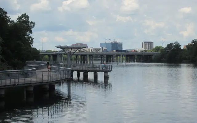 Lady Bird Lake boardwalk curving over calm water toward the city
