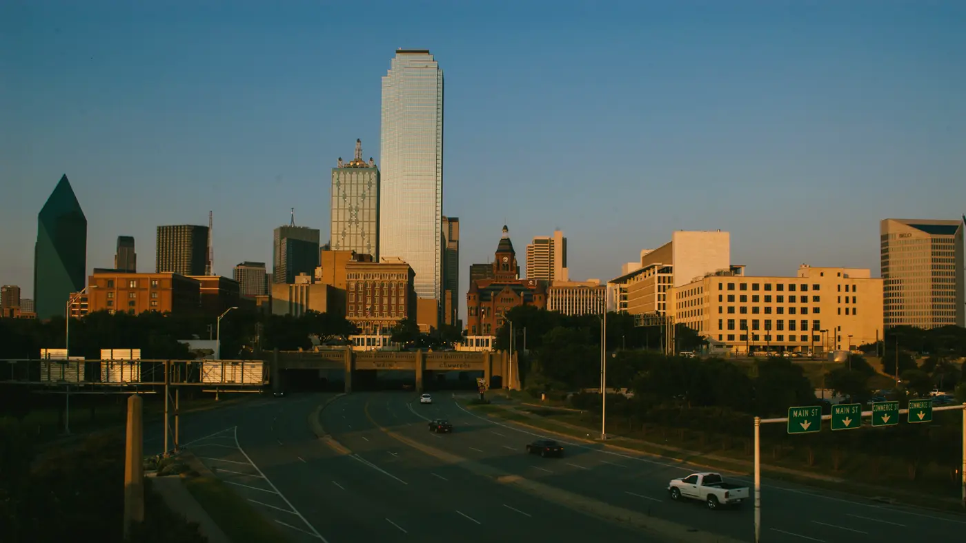 Dallas skyline in golden light above an empty freeway