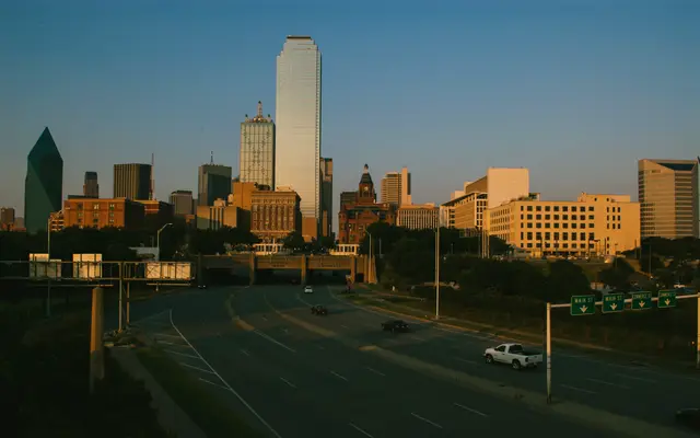 Dallas skyline in golden light above an empty freeway