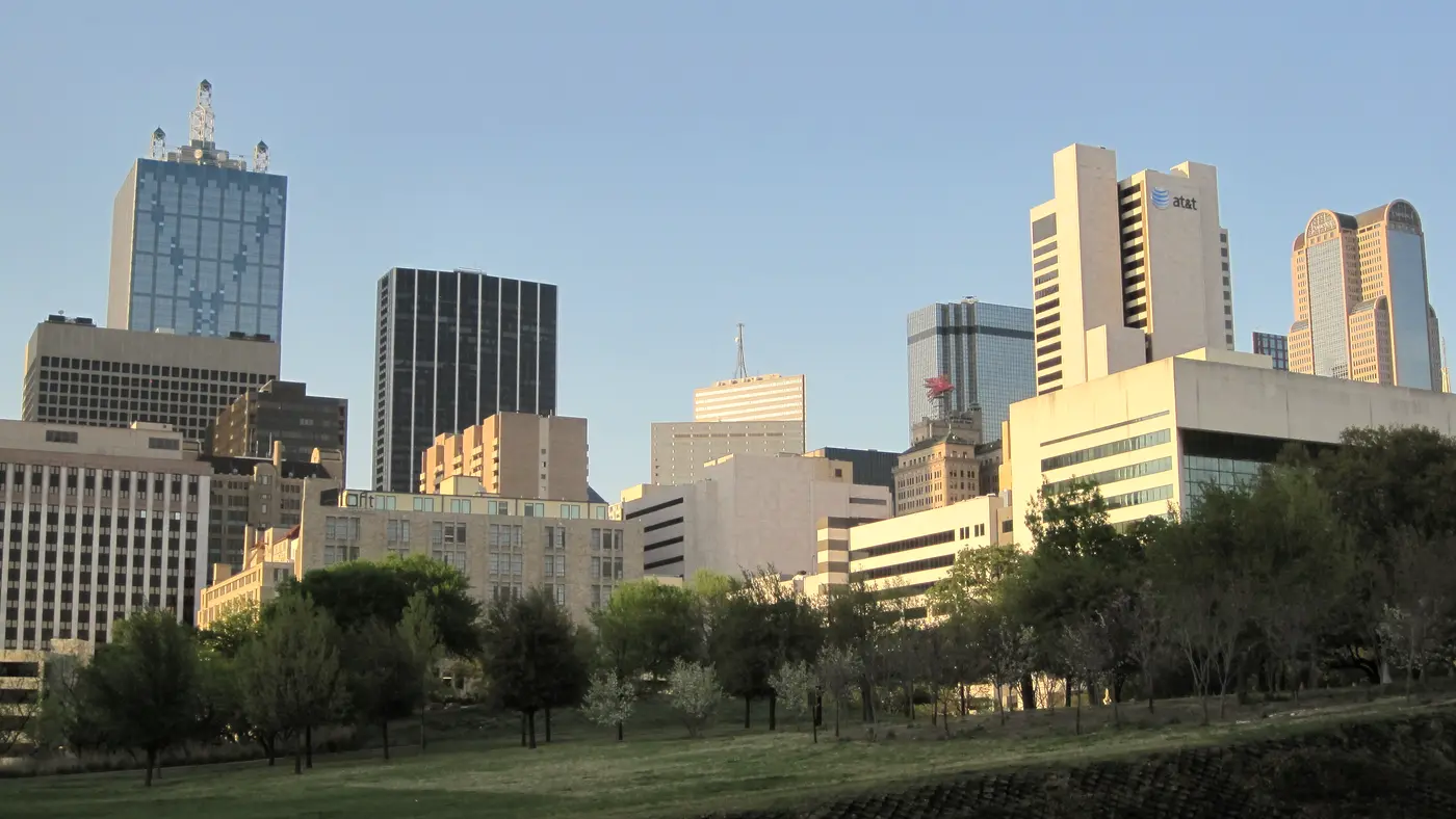 Downtown Dallas towers seen across a green park lawn