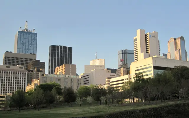 Downtown Dallas towers seen across a green park lawn