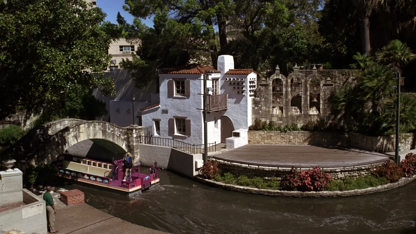 River Walk barge passing the stone bridge and open-air riverside theatre