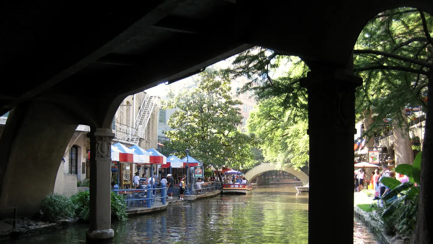 San Antonio River Walk cafés and umbrellas framed by a stone arch