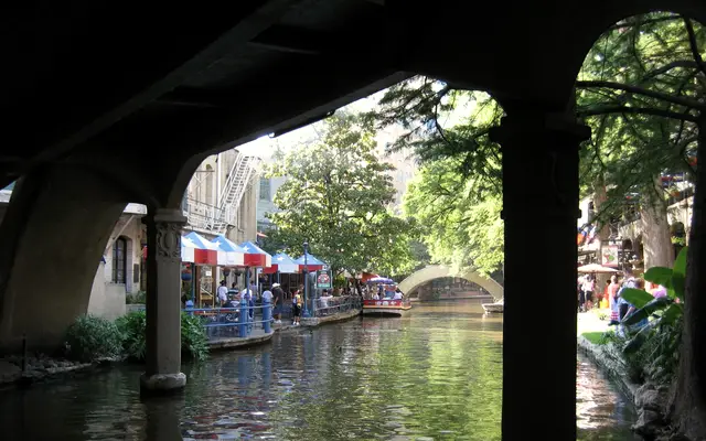 San Antonio River Walk cafés and umbrellas framed by a stone arch