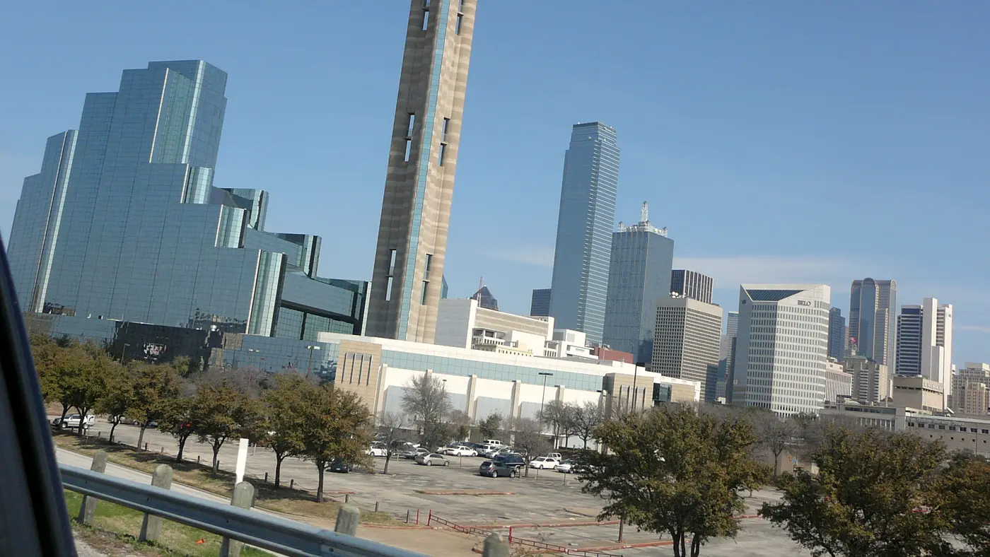 Reunion Tower beside glass hotel towers in downtown Dallas