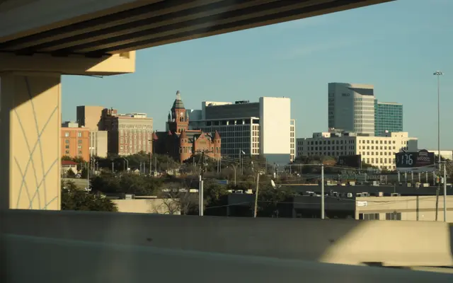 Old Red Courthouse and Dallas towers framed beneath an overpass