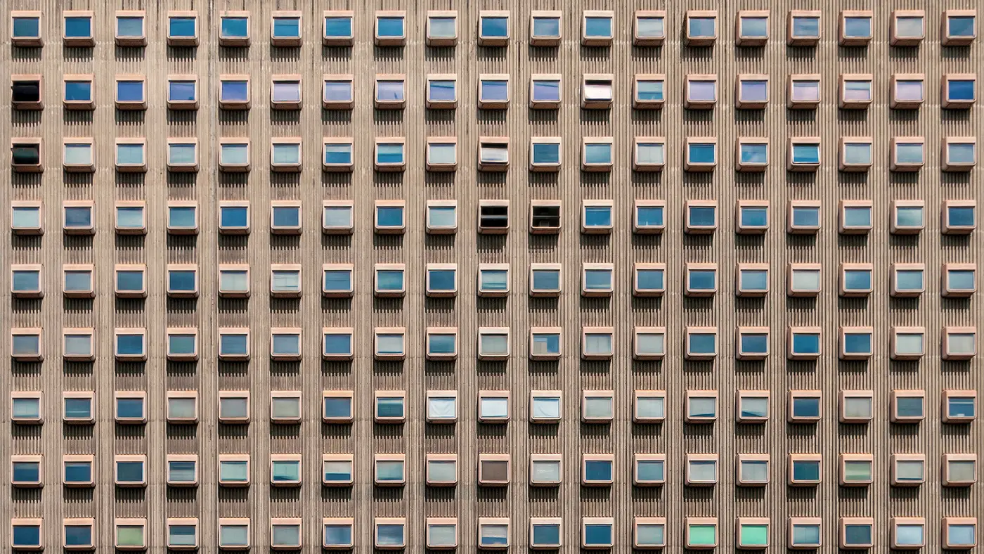 Office tower facade with a regular grid of small windows