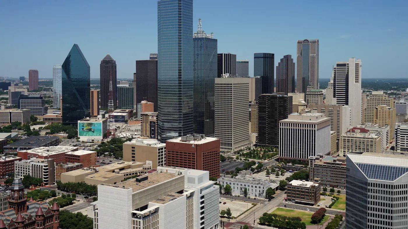 Downtown Dallas skyline of glass towers under a clear blue sky