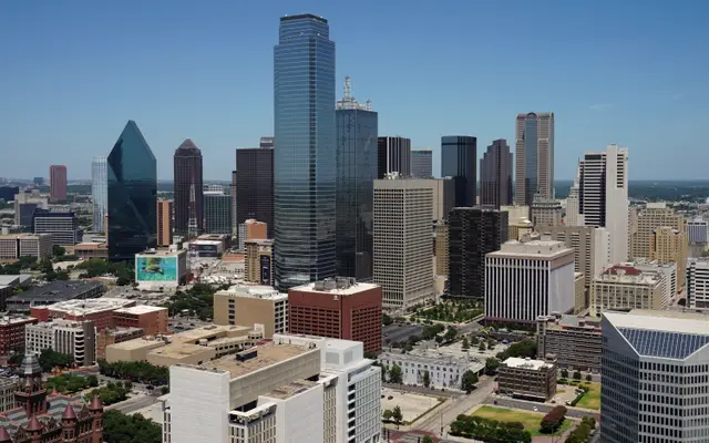 Downtown Dallas skyline of glass towers under a clear blue sky