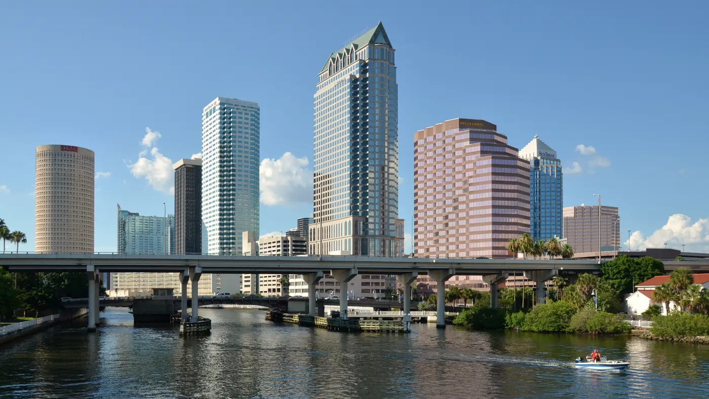 Downtown office towers rising above a river and highway bridge