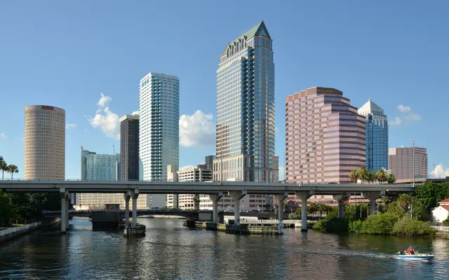 Downtown office towers rising above a river and highway bridge