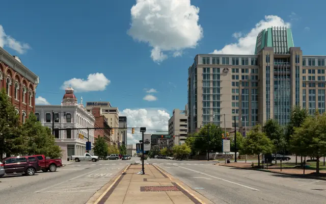 Wide empty downtown street lined with historic and modern buildings
