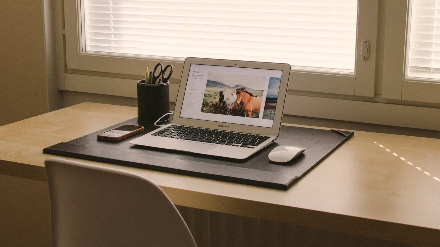 Open laptop on a desk beside a bright window