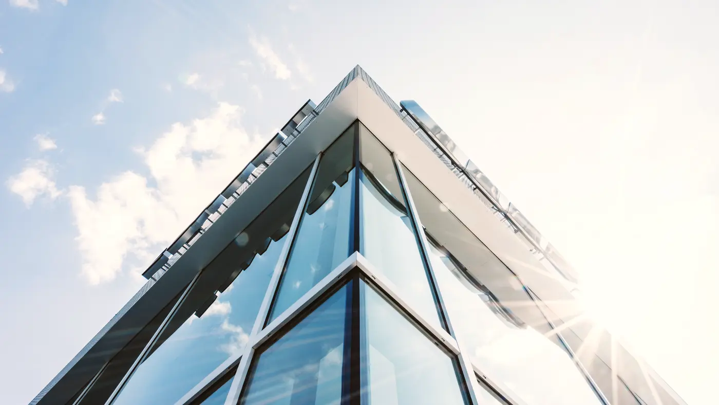 Angular glass building corner against a bright sky