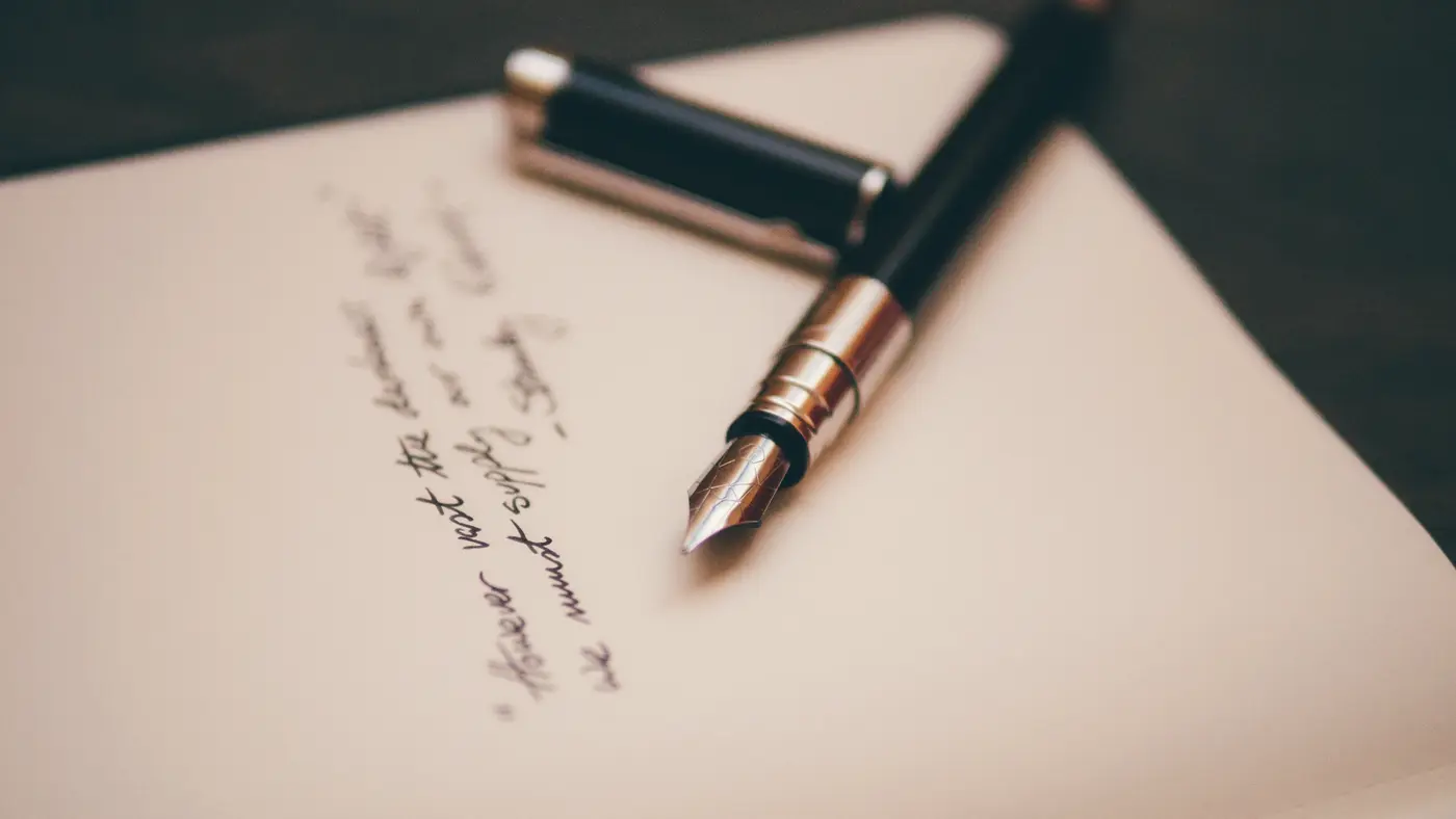 Fountain pen resting on a handwritten note