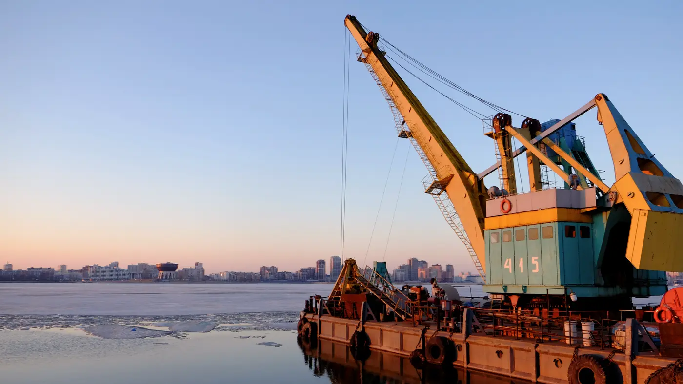 Floating crane barge on calm water at dusk