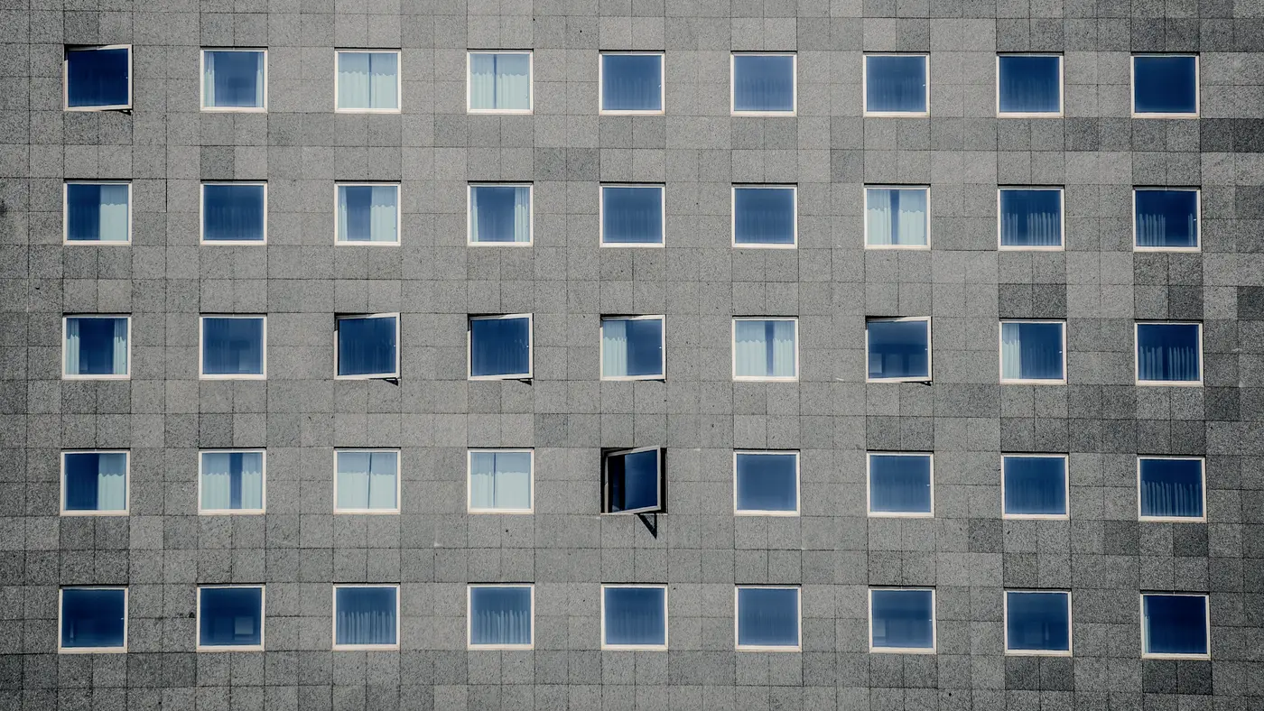 Grid of windows on a grey stone office building facade