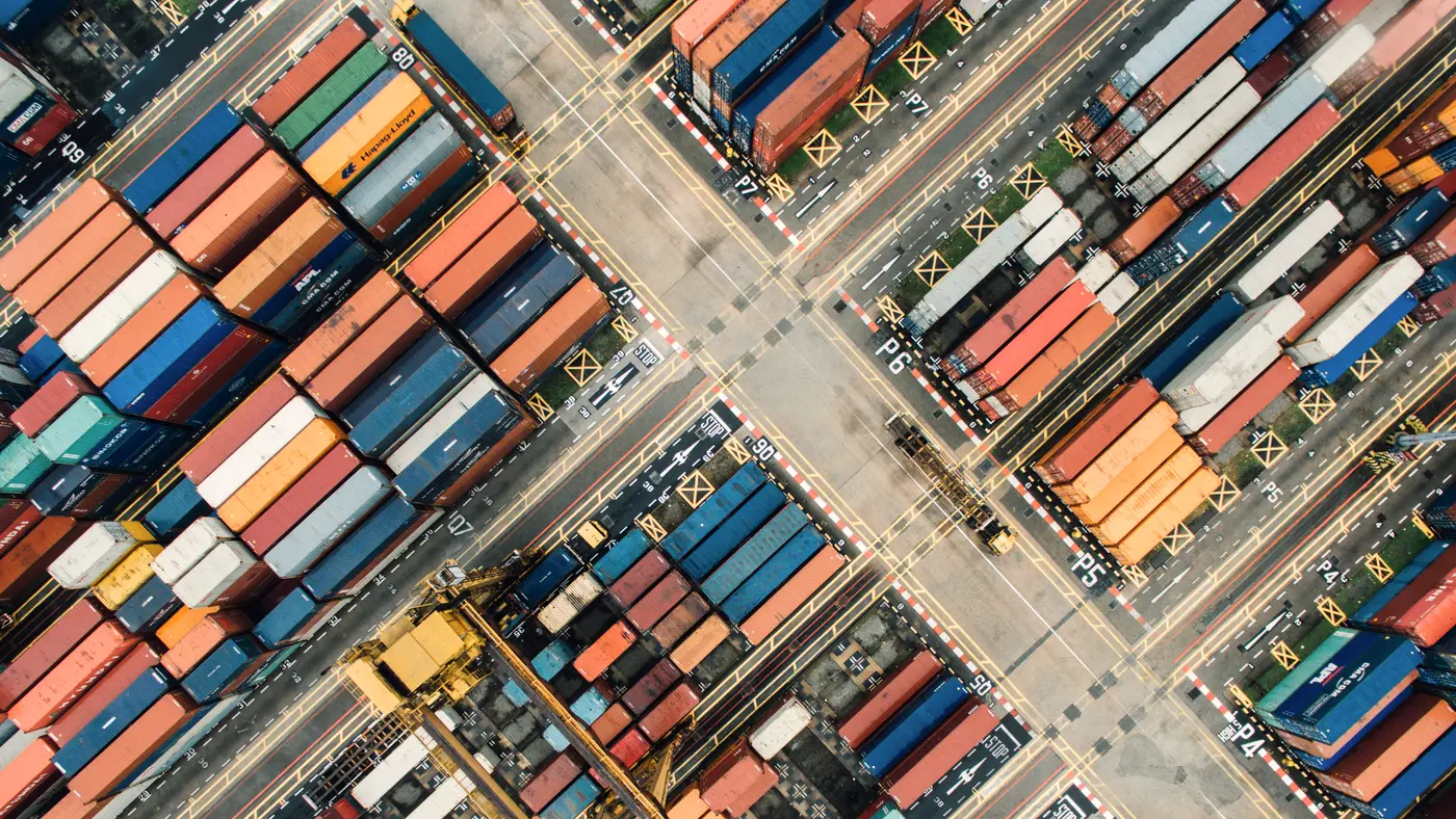 Aerial view of stacked shipping containers and cranes at a port