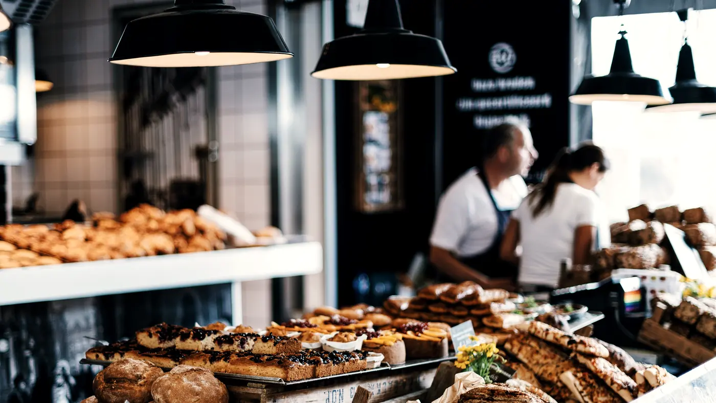 Bakery staff working behind a counter full of fresh bread