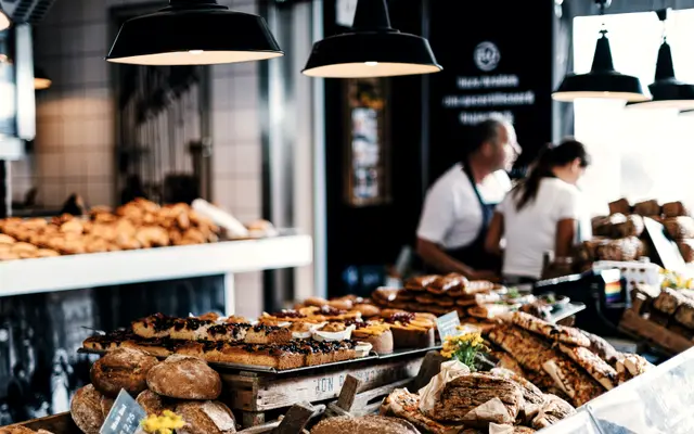 Bakery staff working behind a counter full of fresh bread