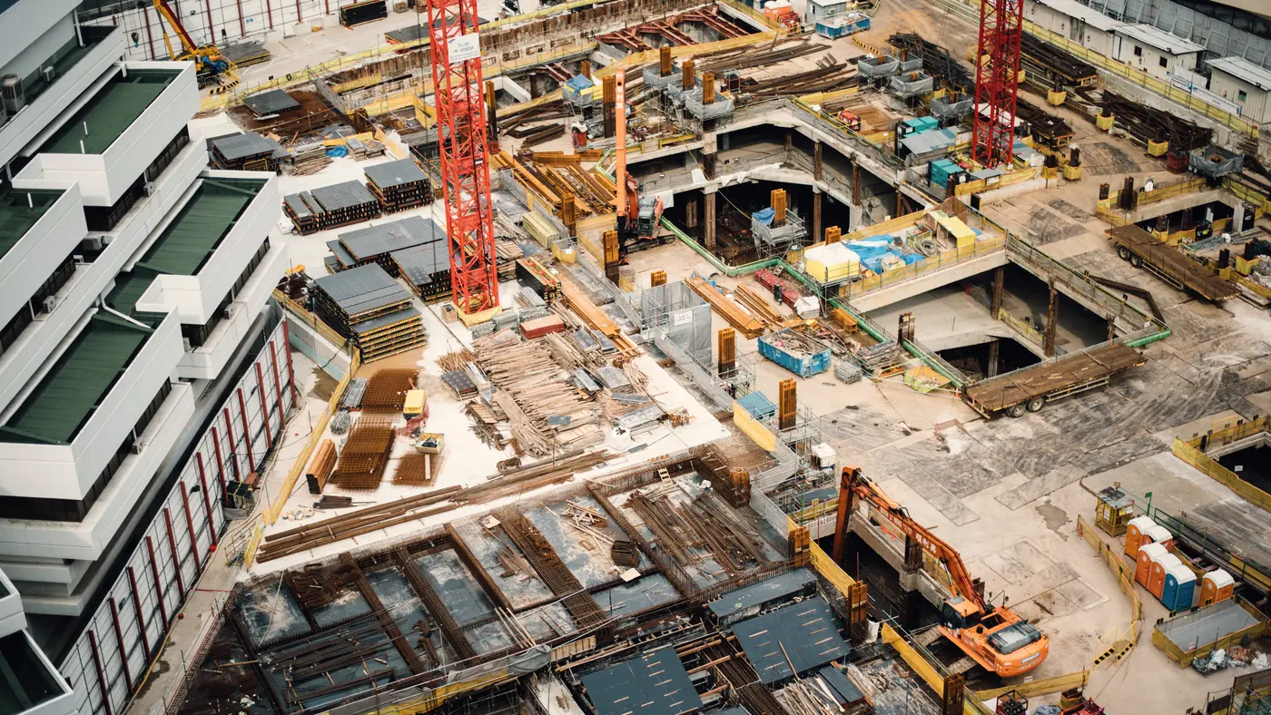 Aerial view of a large downtown construction site with cranes