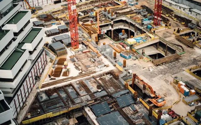 Aerial view of a large downtown construction site with cranes