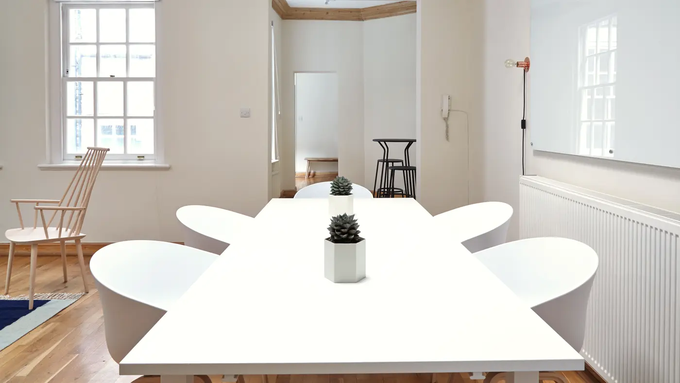Bright meeting room with a long white table and chairs