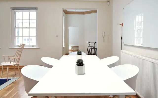 Bright meeting room with a long white table and chairs