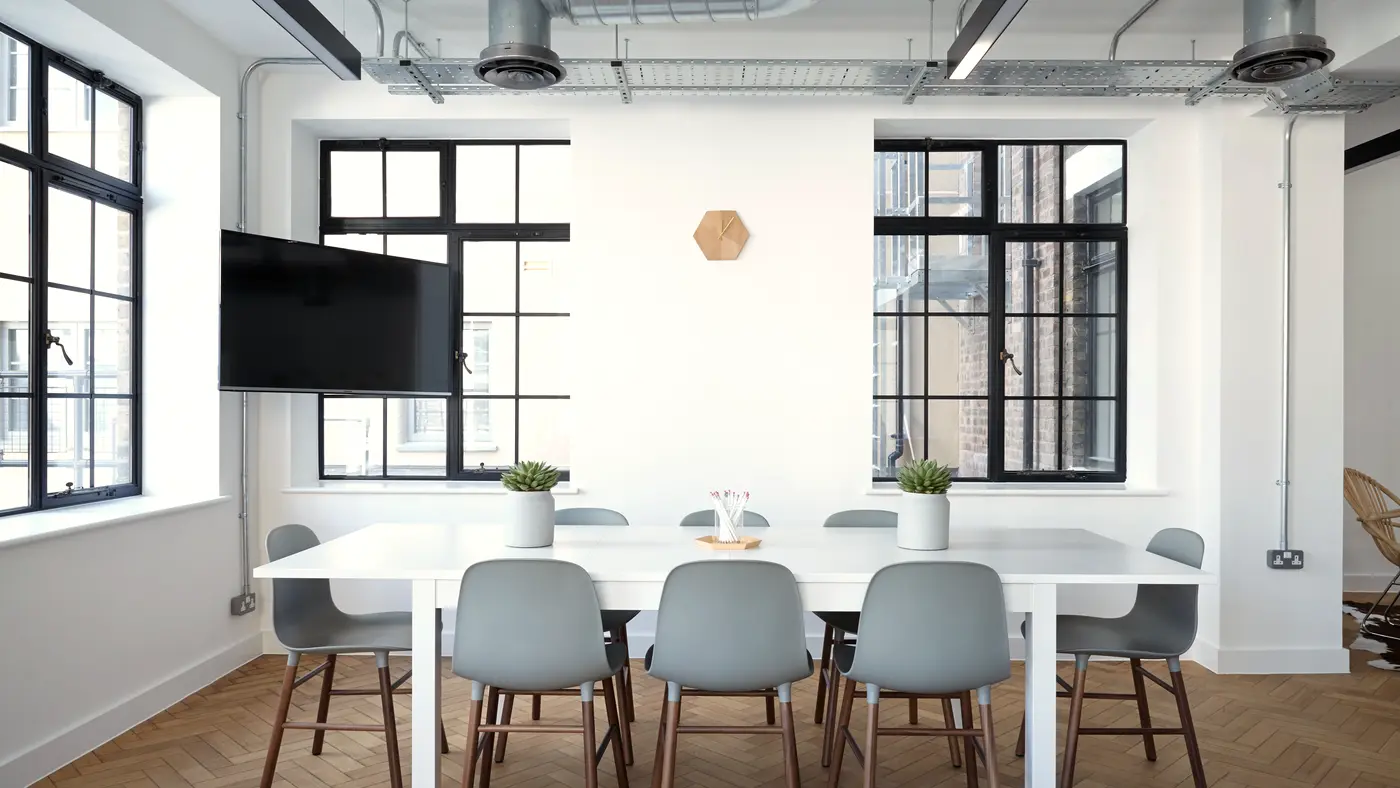 Bright conference room with a white table and tall windows