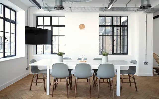 Bright conference room with a white table and tall windows