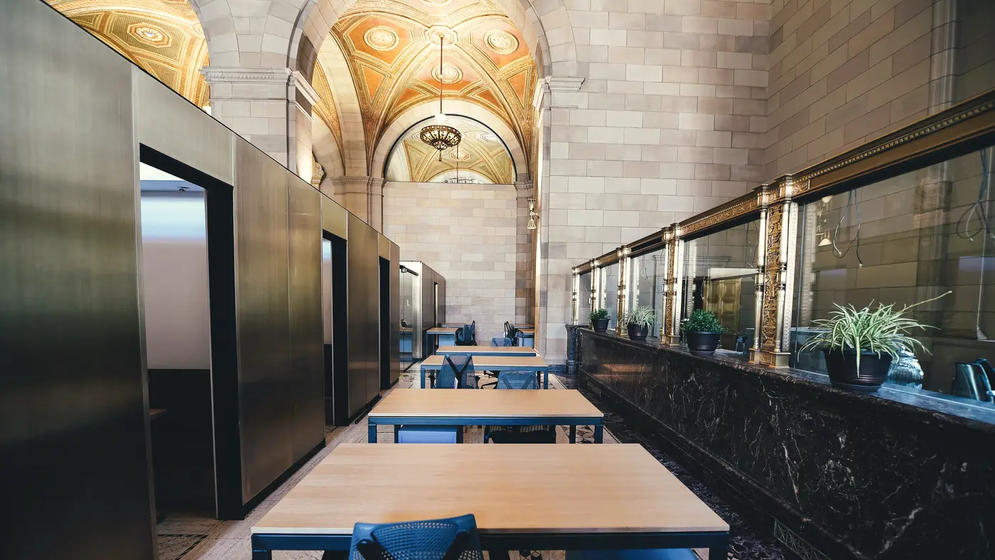 Rows of desks in a grand arched former bank hall