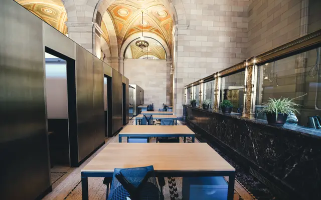 Rows of desks in a grand arched former bank hall