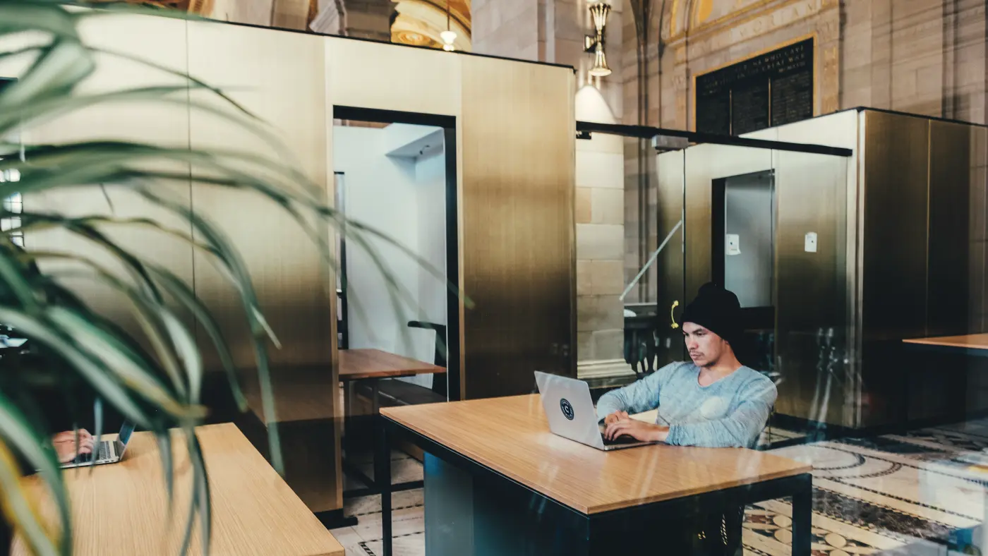 Man working on a laptop at a desk in a shared office