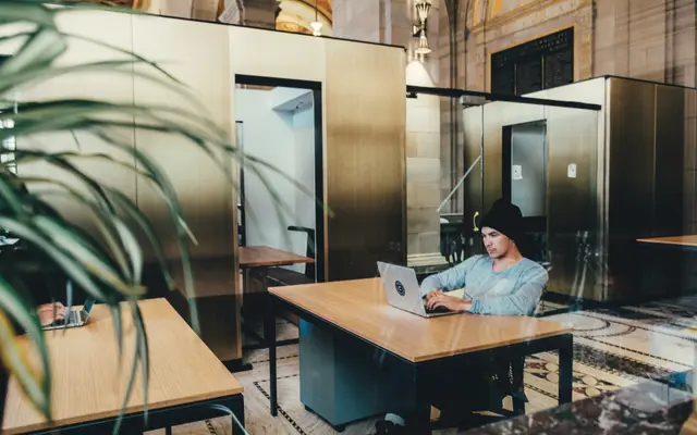 Man working on a laptop at a desk in a shared office