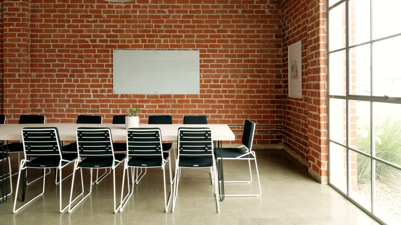 Meeting room with a long table and exposed brick wall