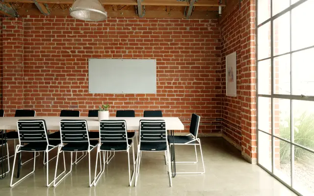 Meeting room with a long table and exposed brick wall
