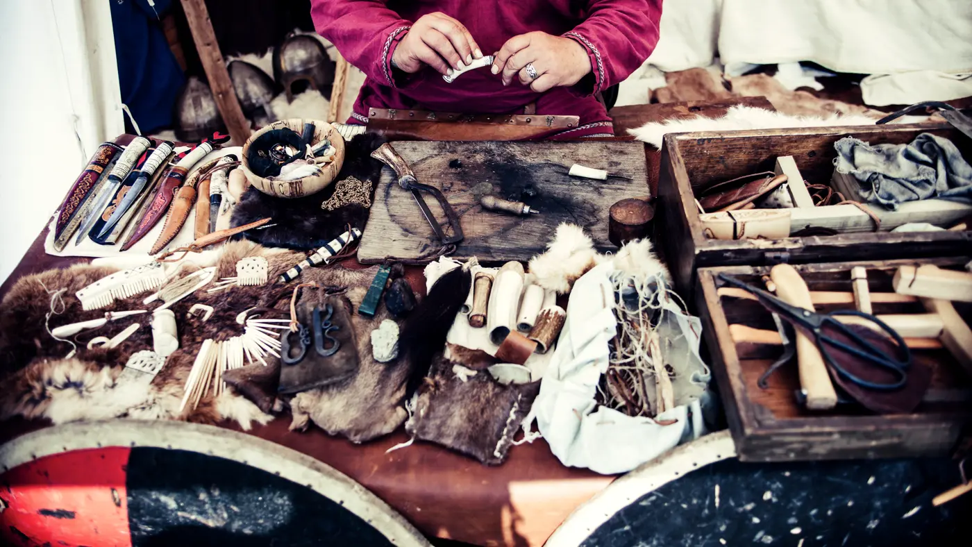 Artisan working at a bench covered with leather and tools
