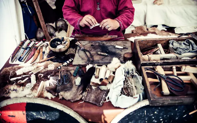Artisan working at a bench covered with leather and tools