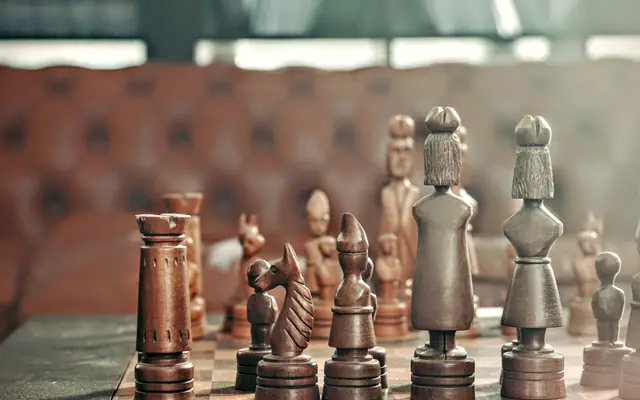 Carved wooden chess pieces on a board in a lounge