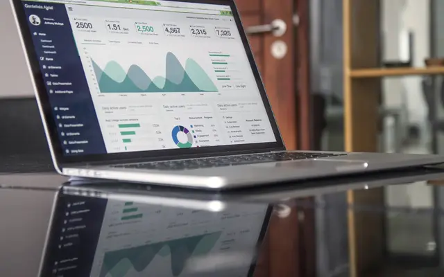 Laptop screen showing a business analytics dashboard with charts