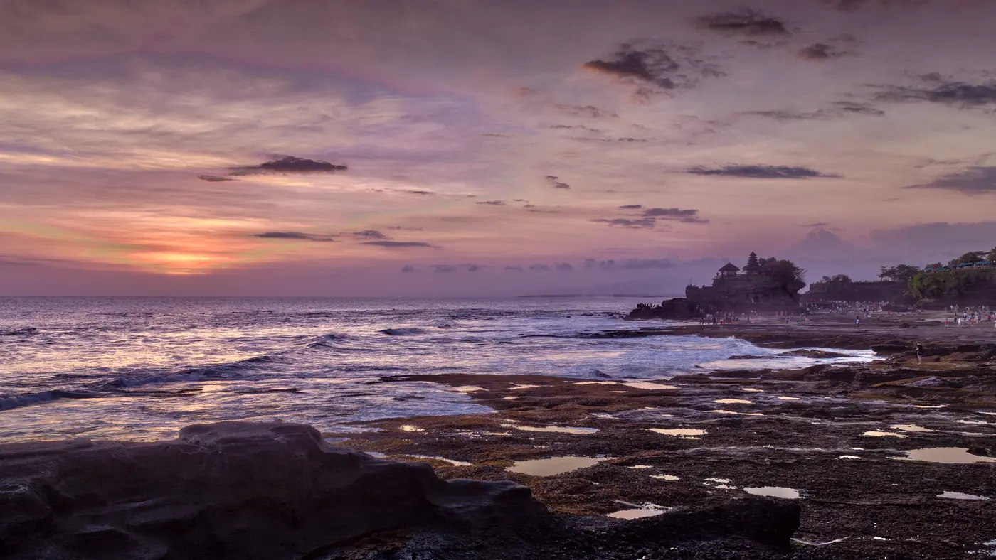 Calm purple sunset over a rocky shoreline