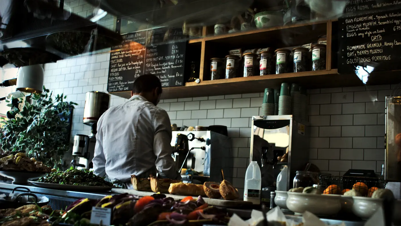 Owner working behind the counter of a small cafe