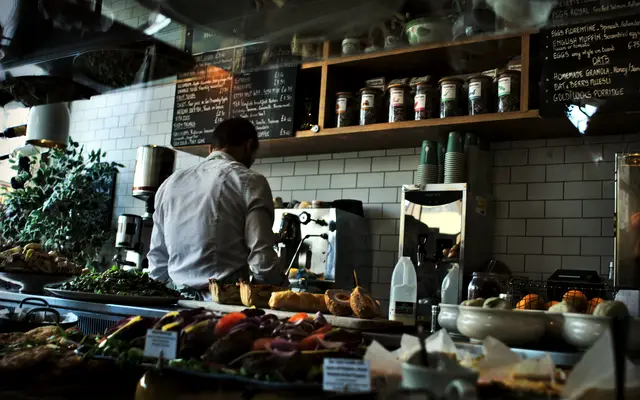 Owner working behind the counter of a small cafe