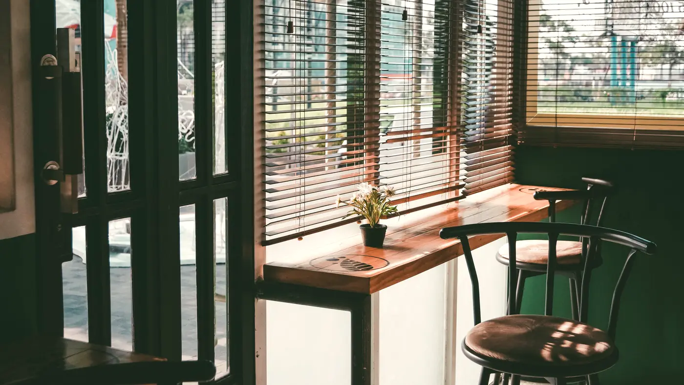 Quiet cafe interior with window seating and wooden stools
