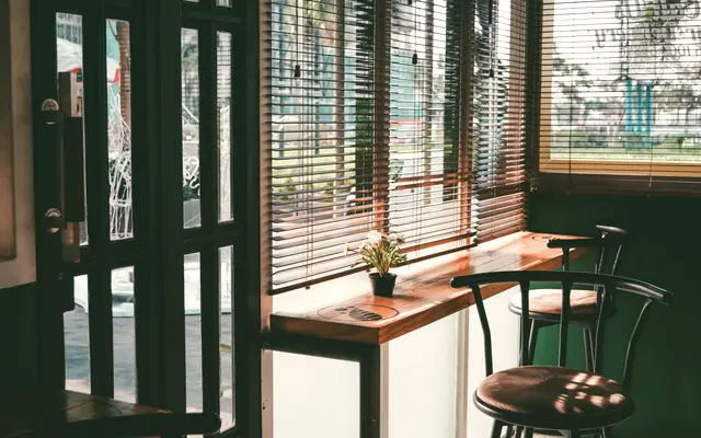Quiet cafe interior with window seating and wooden stools