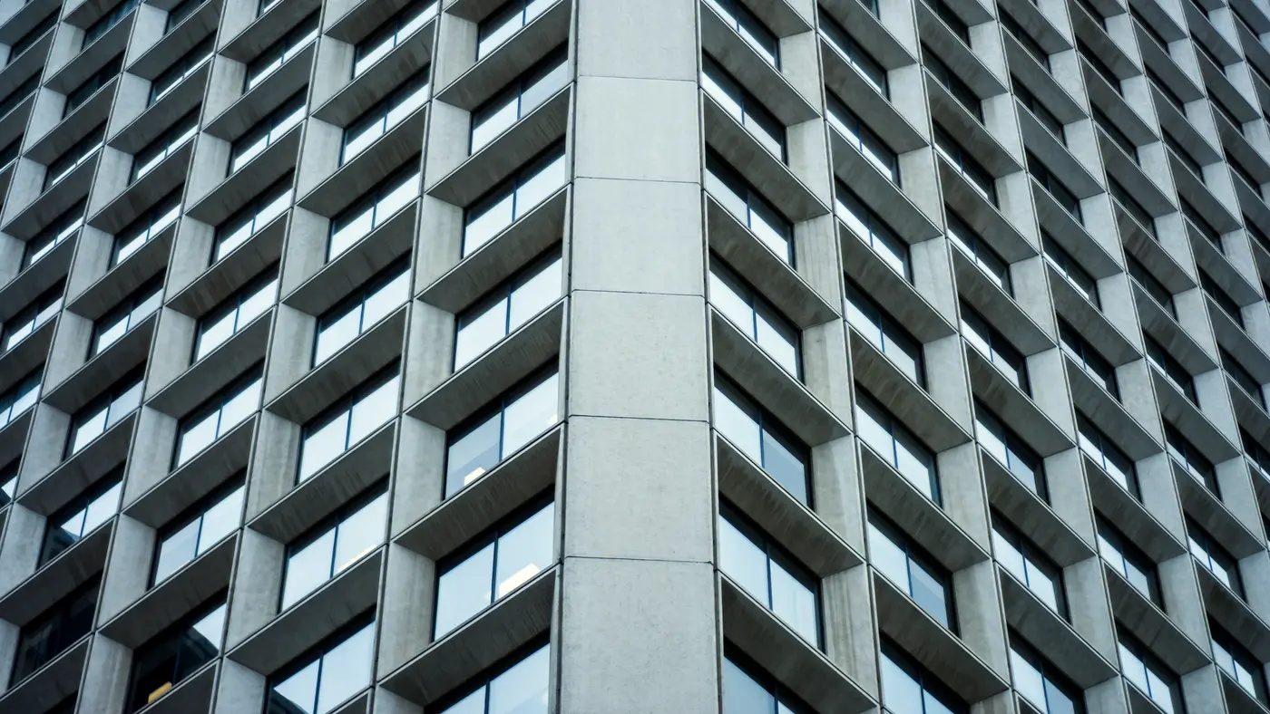 Grid of recessed windows on a concrete office building facade