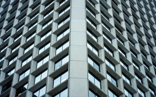 Grid of recessed windows on a concrete office building facade