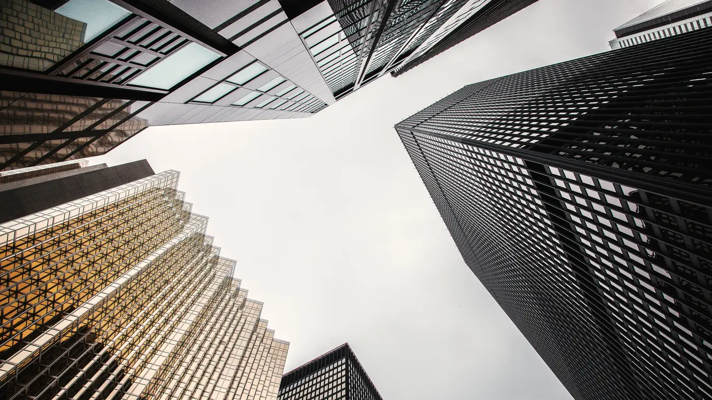 Looking up at gold and dark glass office towers downtown